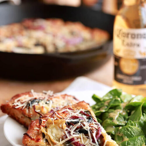 Spinach, Artichoke, Bacon and Mushroom Pizza Slices Served on a White Plate