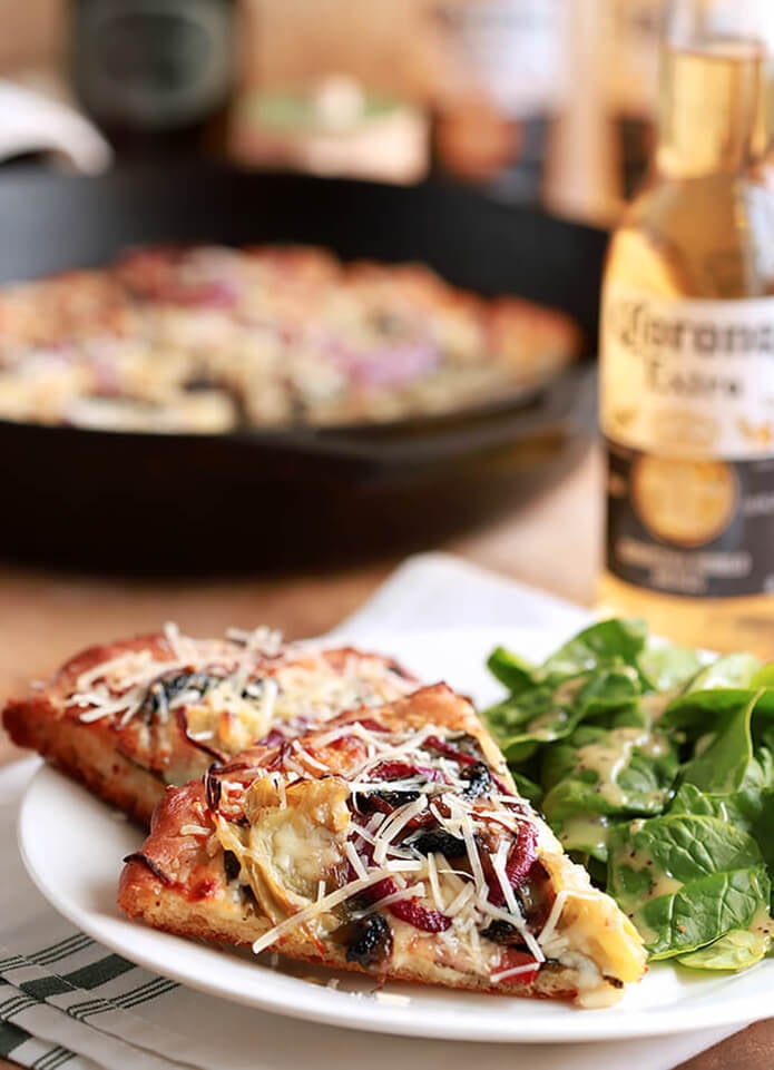 Spinach, Artichoke, Bacon and Mushroom Pizza Slices Served on a White Plate