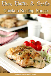 Beer, Butter, and Garlic Chicken Basting Sauce on Chicken Thighs Garnished with Herbs and Served on a White Plate with Tomatoes