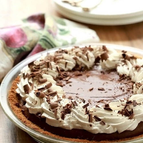 French Silk Pie with Bourbon topped with whipped cream and chocolate curls.