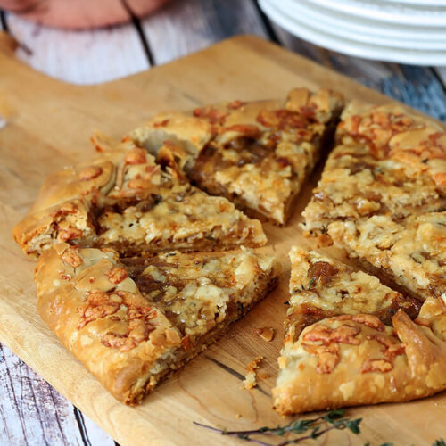 French Onion Galette Sliced, on a Bread Board