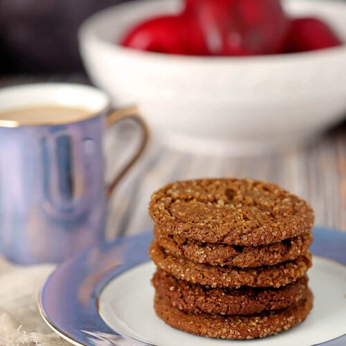 Molasses Cookies on a Blue and White Plate with Apples in the Background