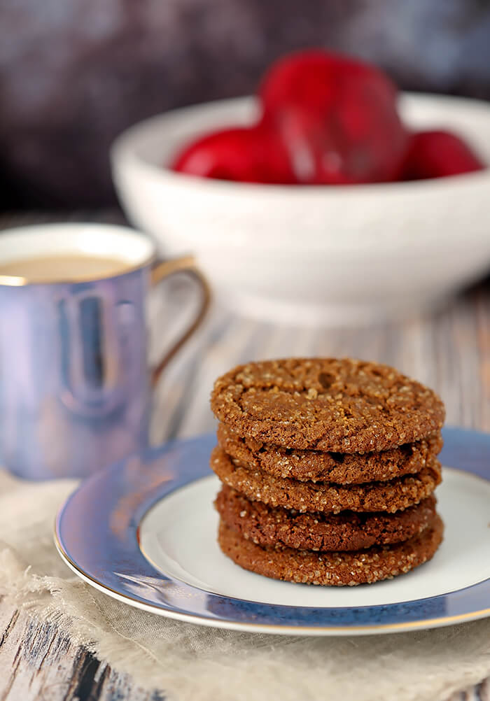 Molasses Cookies on a Blue and White Plate with Apples in the Background