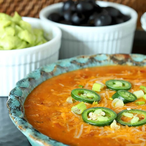 Nacho Mommas Beef, Bean, and Cheese Tortilla Dip Garnished with Jalapeno Slices