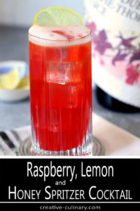 Tom Collins Glass with Sparkling Raspberry, Vodka, and Honey Cocktail Garnished with a Lemon Slice