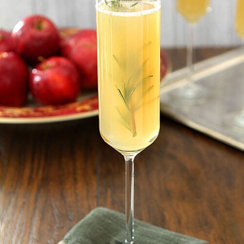 Apple Cider Bellini in Tall Champagne Glasses Garnished with Rosemary