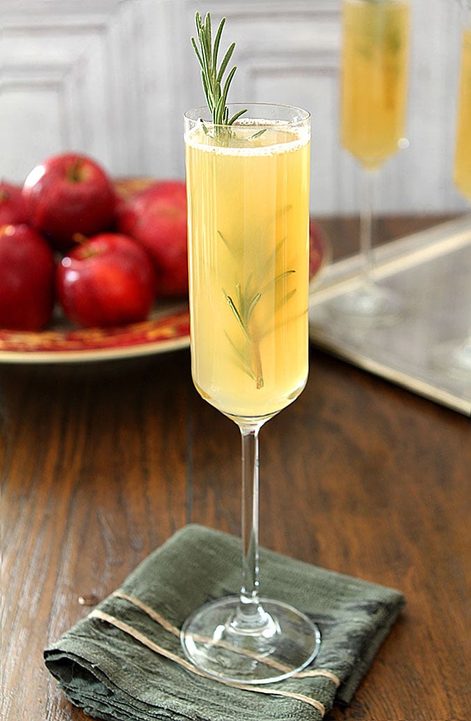 Apple Cider Bellini in Tall Champagne Glasses Garnished with Rosemary