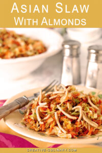 A serving of Asian Slaw with Almonds on a serving plate with colorful pink and green napkin.