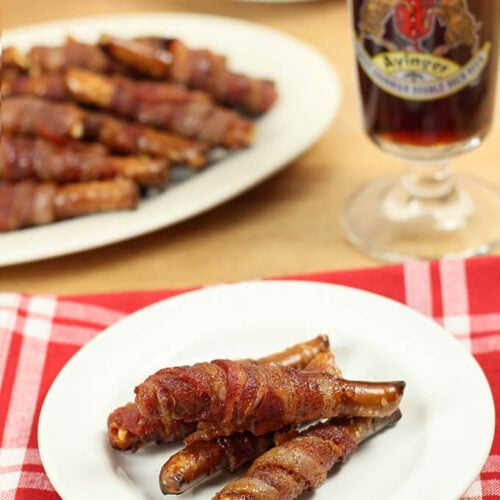 Bacon Wrapped Pretzel Rods Served with a Glass of Dark Beer.