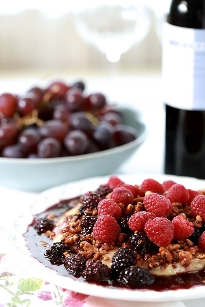 Baked Brie with Fresh Berries and Walnuts Served with Grapes and Cabernet Wine