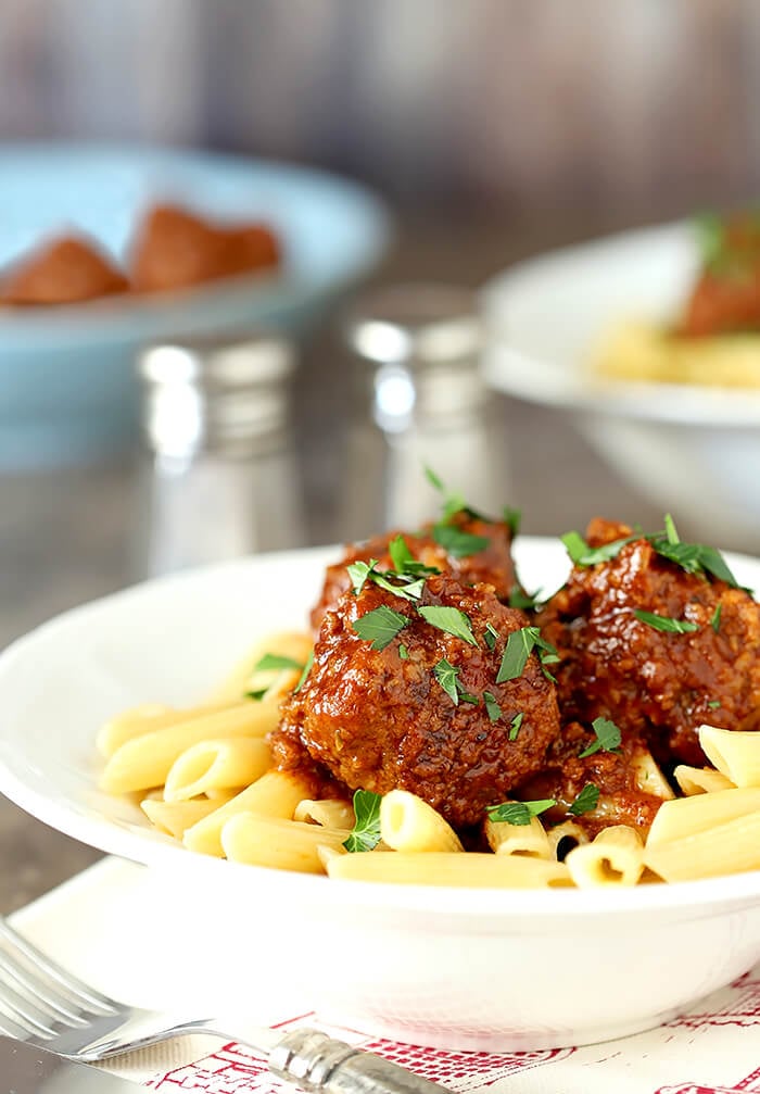 Plate of Beef, Bourbon, and Bacon Meatballs on Penne Pasta Garnished with Parsley