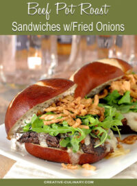 Beef Pot Roast Sandwich with Arugula and French Fried Onion Rings on White Plate