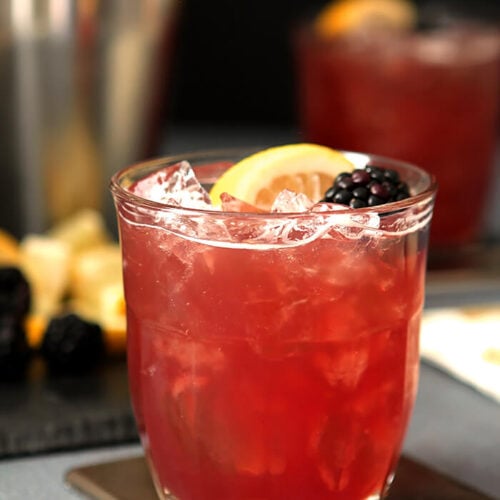 Blackberry Bourbon and Cranberry Cocktail with Lemon Wedge and Blackberry Garnish