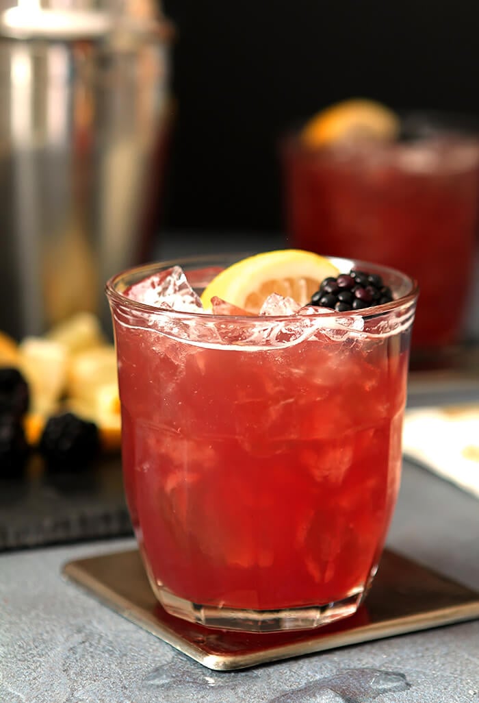 Blackberry Bourbon and Cranberry Cocktail with Lemon Wedge and Blackberry Garnish