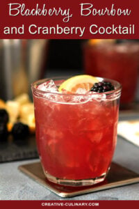 Blackberry, Bourbon, and Cranberry Cocktail in Lowball Glass with Lemon Wedge and Blackberry Garnish