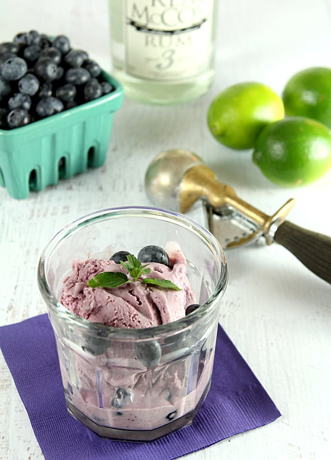 Blueberry Mojito Ice Cream on a White Tabletop with Berries and Limes