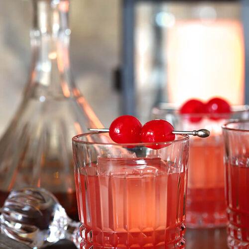 Bourbon and Cherry Old Fashioned Cocktail Served in Glasses with Maraschino Garnish