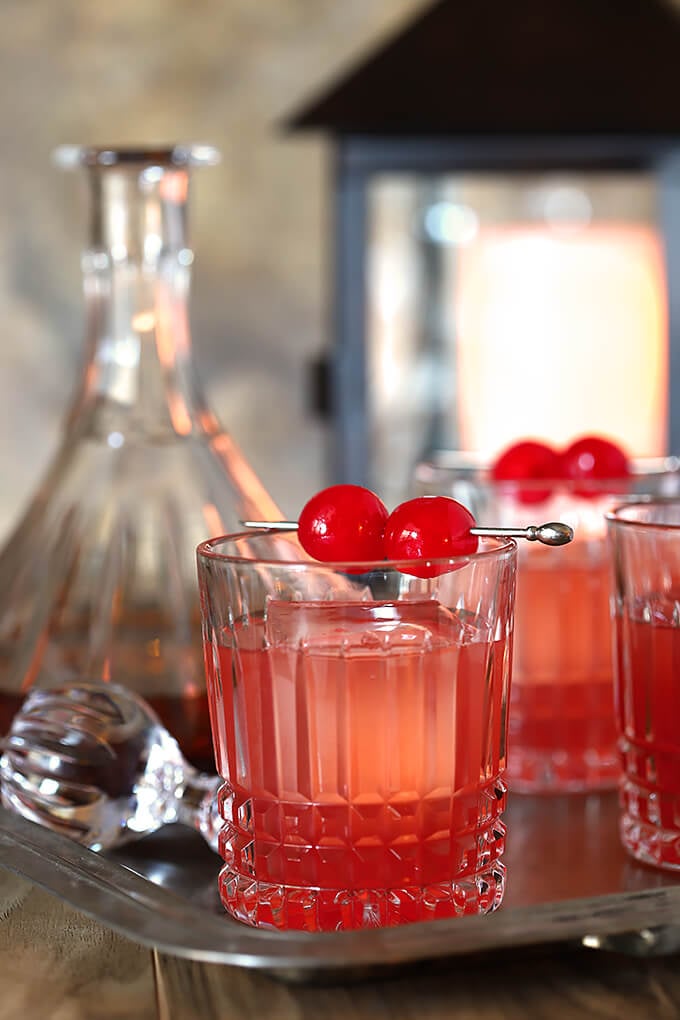 Bourbon and Cherry Old Fashioned Cocktail Served in Glasses with Maraschino Garnish