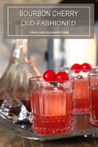 Bourbon Cherry Old Fashioned Cocktails with Maraschino Cherry Garnish in Setting with Cocktails and Decanter