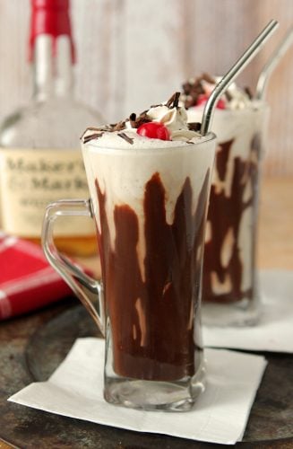 Hot Fudge and Bourbon Milkshake Served in a Ice Cream Soda Glass with a Stainless Steel Straw.