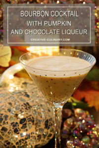 Bourbon Cocktail with Pumpkin and Chocolate Liqueur Served in a Gold Sparkle Martini Glass in Front of Sparkling Holiday Decor