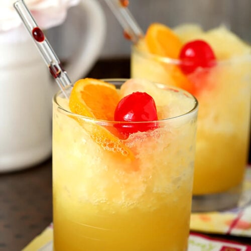 Brandy Slush Cocktails with Glass Straws and Fruit Garnish