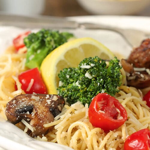 Closeup of Pasta with Broccoli, Tomato, Mushrooms, and Parmesan Cheese