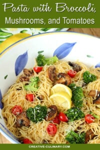 Pasta with Broccoli, Tomato, Mushrooms, and Parmesan Cheese in a Large White, Blue and Yellow Pasta Bowl