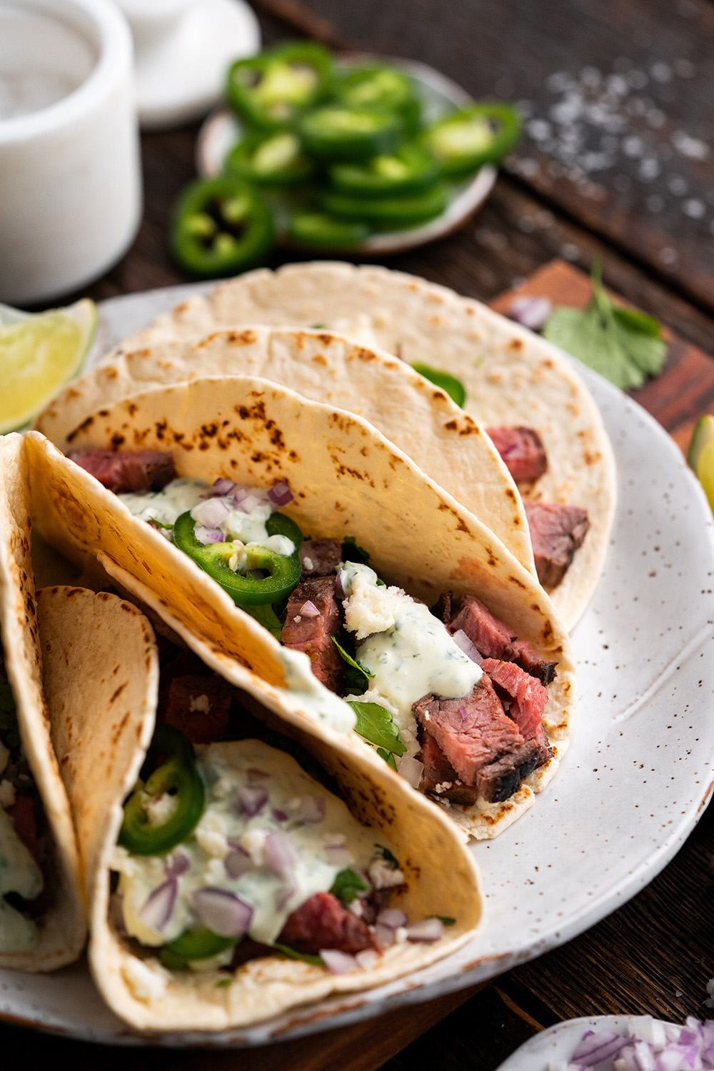 Plate of three Carne Asado Steak Tacos with Cilantro Sauce.