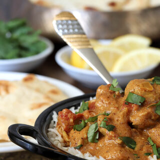 Easy Chicken Curry Served in Black Bowl with Lemon Garnish