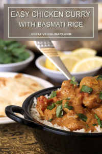 Easy Chicken Curry in Bowl and Table filled with Bread and Condiments