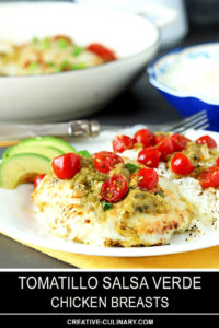 Tomatillo Salsa Verde Chicken Breasts on a White Plate with Avocado and Cherry Tomatoes