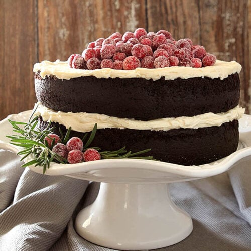 Chocolate Cake with Whipped Cream and Mascarpone Frosting Topped with Sugared Cranberries. The Perfect Cake for Christmas!