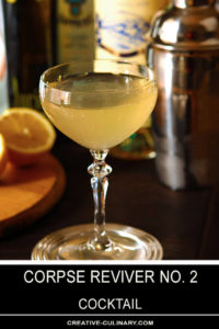 Corpse Reviver No 2 Cocktail in a Coupe Glass with Orange Halves in Background