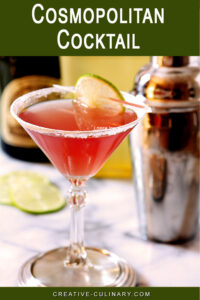 Cosmopolitan Cocktail on Marble Surface with Cocktail Shaker in Background.