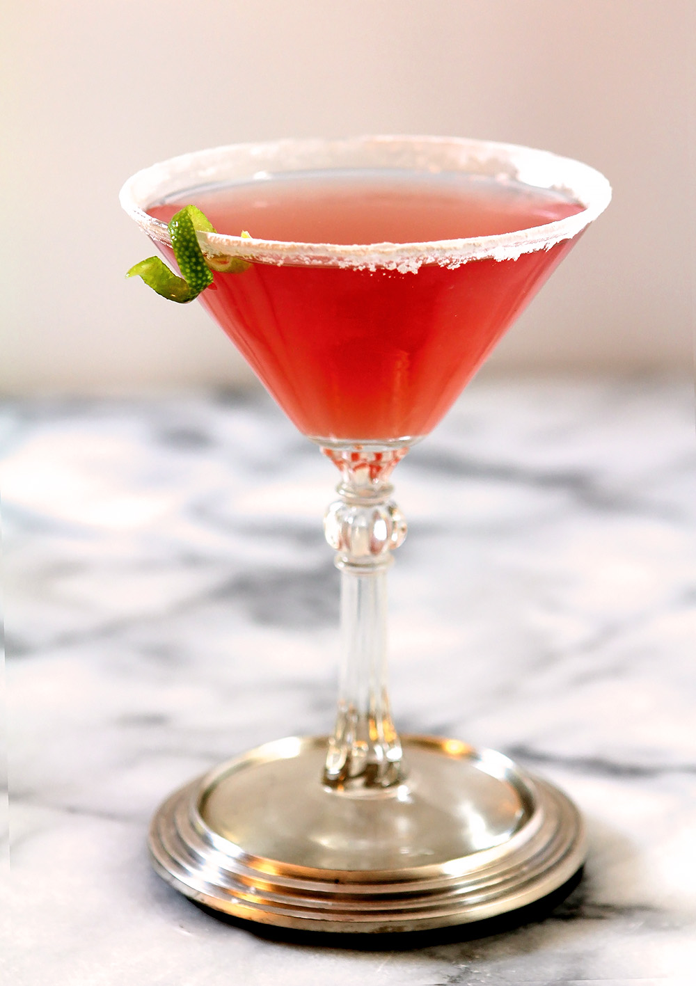 Cosmopolitan Pink Cocktail on Marble Table with Lime Garnish