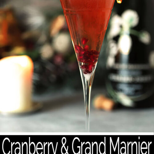 Cranberry and Grand Marnier Champagne Cocktail Served in a Tall Champagne Glass with an Orange Twist