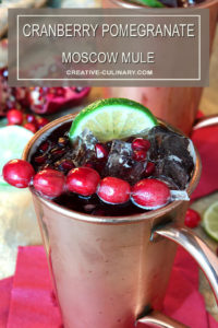 Cranberry Pomegranate Moscow Mule Garnished with Cranberries and a Lime Wedge