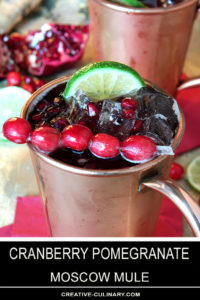 Cranberry Pomegranate Moscow Mule Garnished with Cranberries and a Lime Wedge