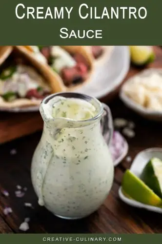 Creamy Cilantro Sauce and Dressing in glass carafe and flank steak tacos in background.