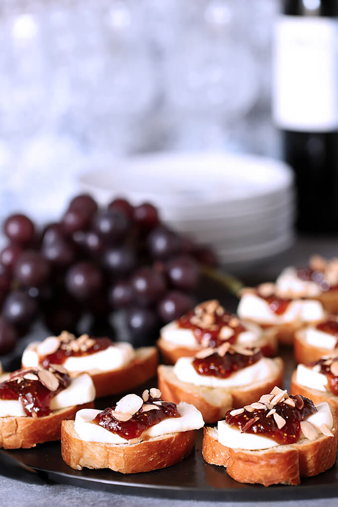 Fig Jam and Brie Crostini with Toasted Almonds on a Serving Tray with Grapes