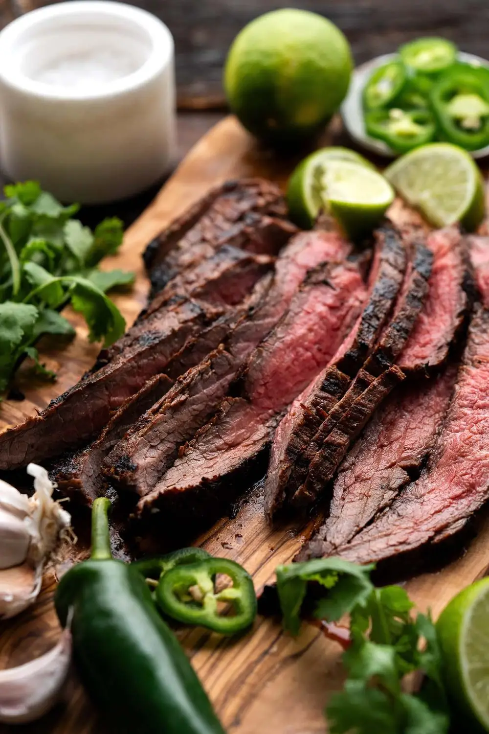 Sliced pieces of Carne Asada Mexican Flank Steak on a cutting board.