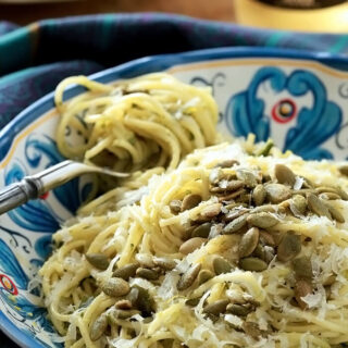 Green Spaghetti with a Poblano Cream Sauce in a bowl with a forkful twirled with spaghetti on the side.