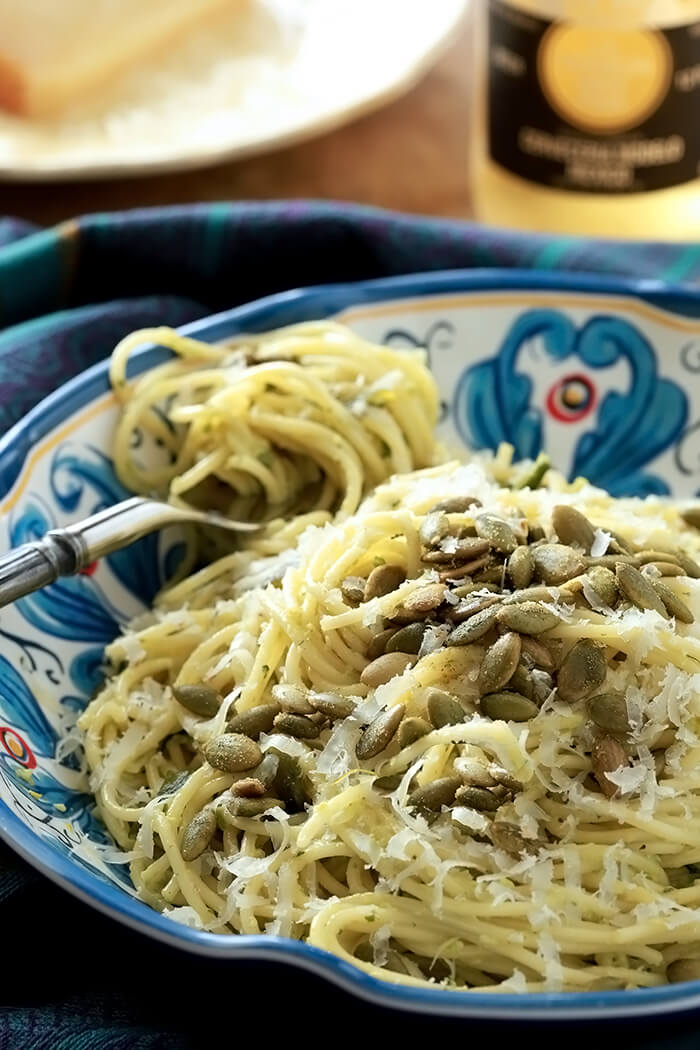 Green Spaghetti with a Poblano Cream Sauce in a bowl with a forkful twirled with spaghetti on the side.