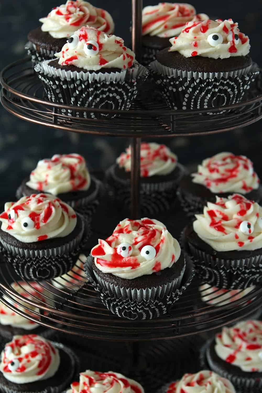 Chocolate Cupcakes for Halloween with candy eyes and red simple syrup to make them look like mummies.