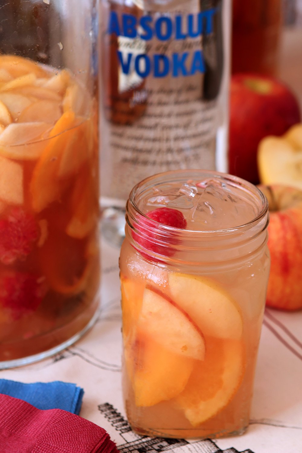 Hard Apple Cider Sangria in mason jar with peaches and raspberry.