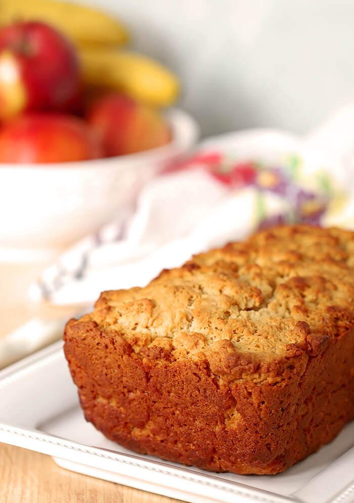 A Full Loaf of Honey Butter Beer Bread on a White Serving Plate