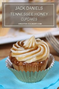 Closeup of Jack Daniels Honey Whiskey Cupcakes with a Boozy Drizzle from a Spoon In a Metallic Cupcake Liner