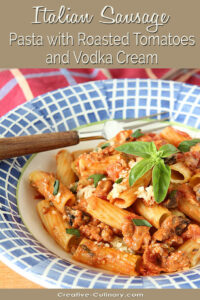 Italian Sausage Pasta with Roasted Tomatoes and Vodka Cream Served in Blue and White Pasta Bowl Garnished with Basil