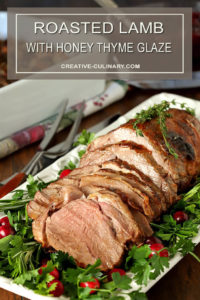 Roasted Lamb with Honey Thyme Glaze Sliced and on Serving Plater with Parsley and Cranberry Garnish